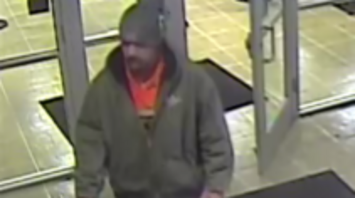 The suspect in Thursday’s bank robbery is described as a white man of medium build who stands about 6 feet tall and was last seen wearing a dark green jacket with an orange shirt.
