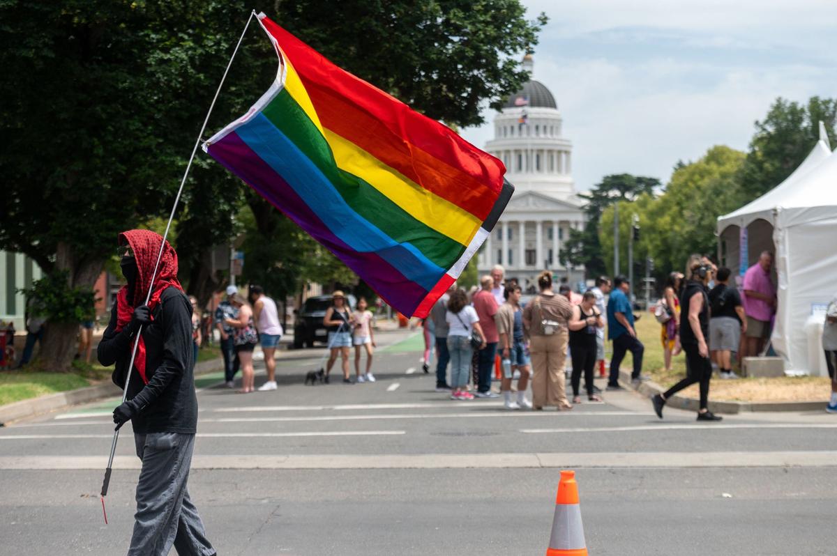 A pro-Palestine protester waves a Pride flag in front of the 33rd annual Sacramento Pride festival on Saturday, June 8, 2024.