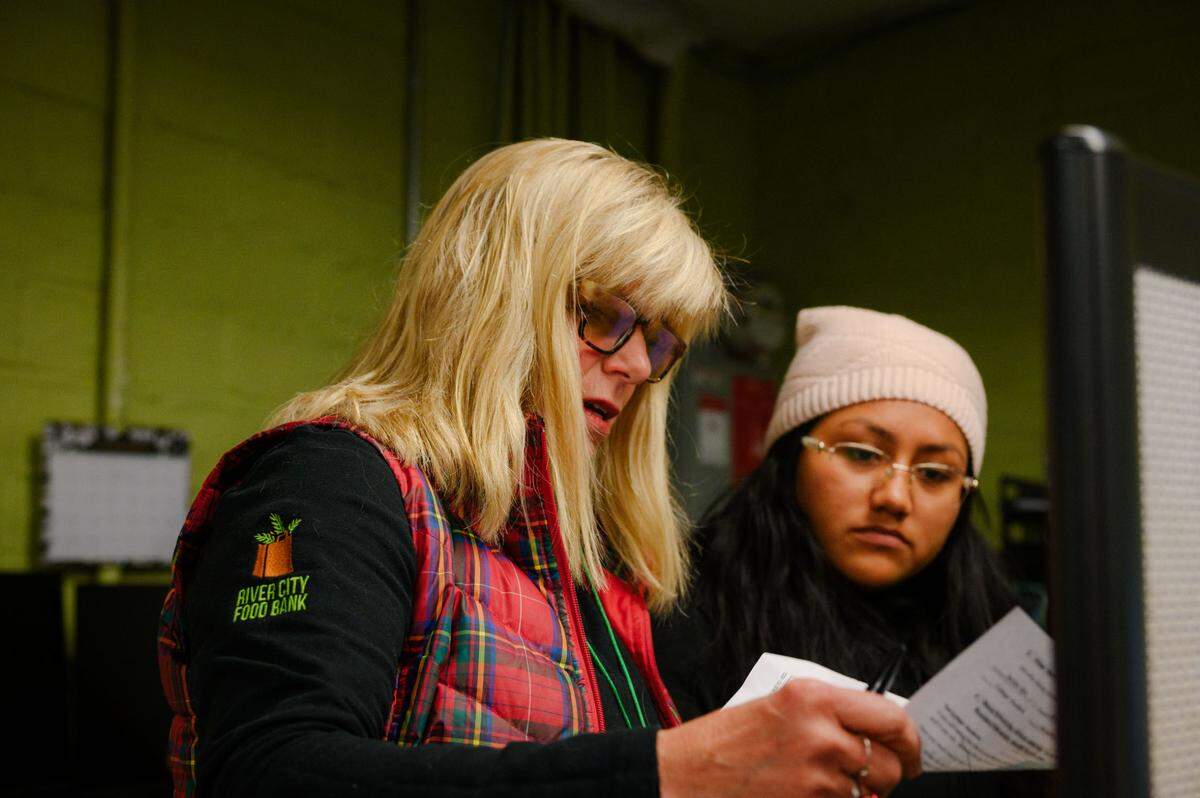 River City Food Bank Calfresh outreach team members Amy Dierlam, left, and Amalia Cruz look at their calendar for the day’s appointments as they prepare to begin the work day at their offices in Sacramento last December.