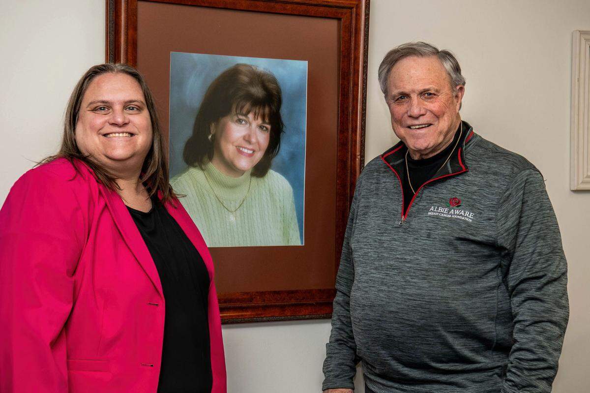 Albie Aware Founder, Doug Carson, stands with Executive Director Courtney Quinn, along side a photo of his late wife Albie at their office last month.