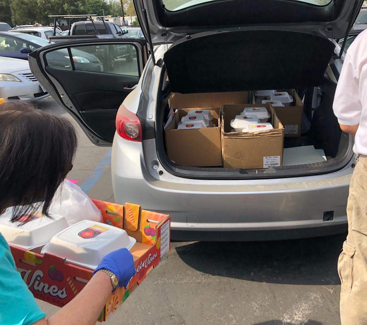 Honey Lum, former CACS president, checks to see if there’s room for one more box of lunches in the back of an organizer’s car.