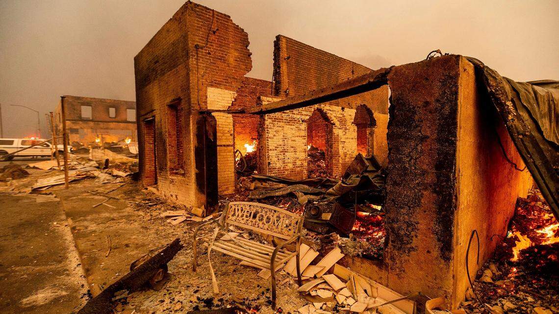 A bench stands outside a scorched building as the Dixie Fire tears through the Greenville community of Plumas County, Calif., on Wednesday, Aug. 4, 2021. The fire leveled multiple historic buildings and dozens of homes in central Greenville.