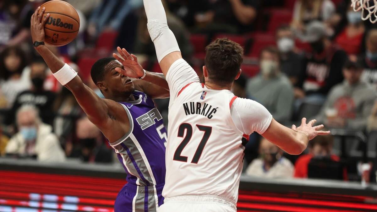 Sacramento Kings guard De’Aaron Fox, left, drives to the basket against Portland Trail Blazers center Jusuf Nurkic, right, during the first half of a preseason NBA basketball game in Portland, Ore., Monday, Oct. 11, 2021. (AP Photo/Steve Dipaola)