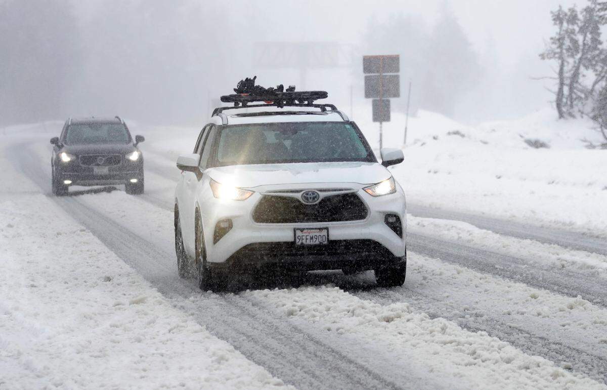 Vehicles slowly make their way along Interstate 80 eastbound as snow begins falling near Kingvale on Thursday, Feb. 29, 2024.