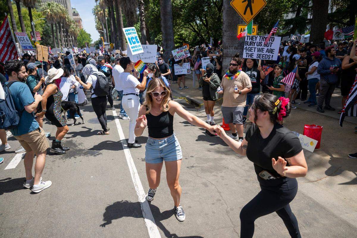 Protesters dance near the state Capitol during the “No Kings” protest against the Trump administration in downtown Sacramento on Saturday.