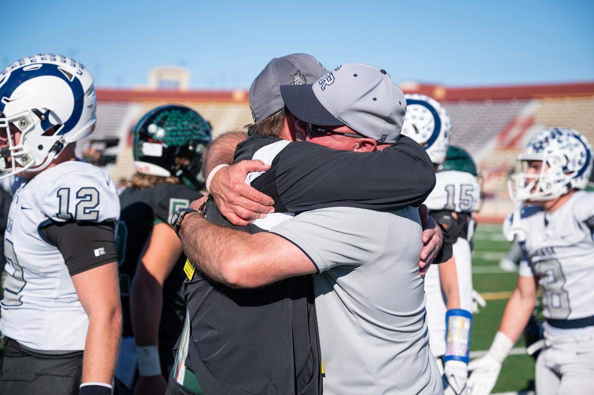 Longtime friends Twelve Bridges Raging Rhinos coach Chris Bean, left, and Casa Roble Rams coach Chris Horner embrace after the Rams’ one-point victory for the CIF Sac-Joaquin Section Division V football championship on Friday at Hughes Stadium.