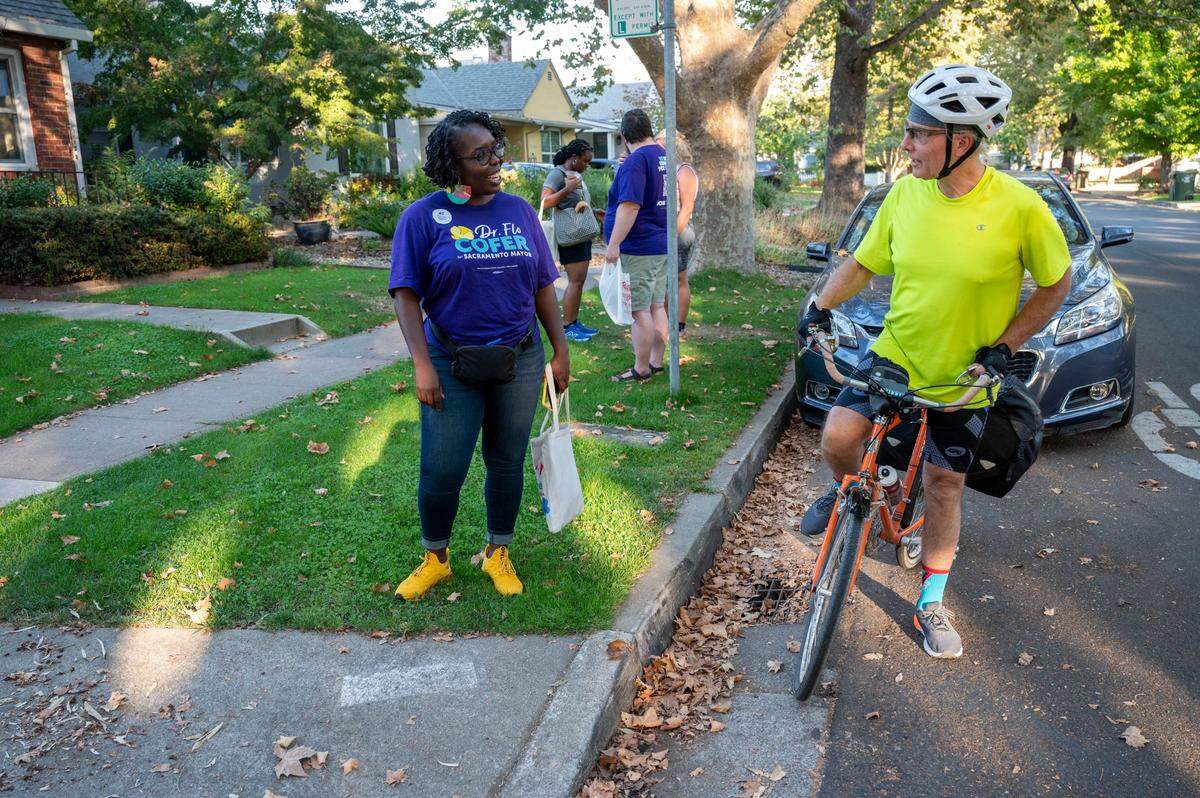 Mayoral candidate Flo Cofer talks with Michael Asher-Falk, a Land Park resident who saw her out canvassing the neighborhood and stopped his bike to meet her Tuesday, Oct. 1, 2024.