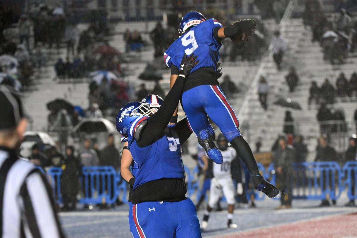Folsom Bulldogs guard Kenny Redhead (54) lifts wide receiver Jameson Powell (9) in the air after he scores a touchdown in the second half of the CIF Sac-Joaquin division I section football semi finals playoff game on Friday, Nov. 17, 2023, at Folsom High School.