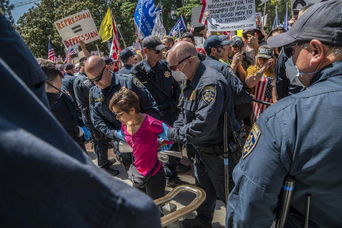 A protester is detained at the Capitol in Sacramento on Friday, May 1, 2020, while demonstrating against Gov. Gavins Newsom stay-at-home order to slow the spread of the coronavirus.