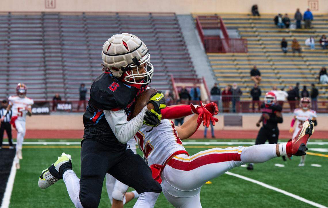 Mira Loma Matadors wide receiver Keion Kado (5) makes a 26-yard touchdown catch against Foresthill Wildfires cornerback David Silveria (12) as time expires in the first half of the CIF Sac-Joaquin Section Division VIII championship at Hughes Stadium in Sacramento on Saturday.