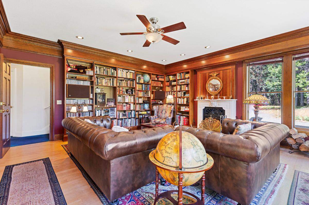 The library has a fireplace with a marble mantle and mohagony walls.