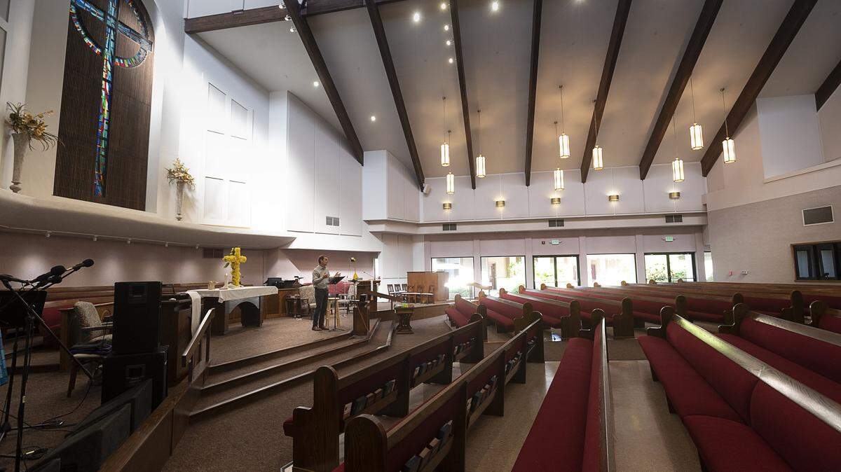 FILE -- Pastor Jeff Chapman uses his iPhone to safely conduct the Faith Presbyterian Church’s Sunday online service to an empty chapel Sunday, April 26, 2020 in Sacramento. Church restrictions due to COVID-19 have loosened in advance of Easter 2021.