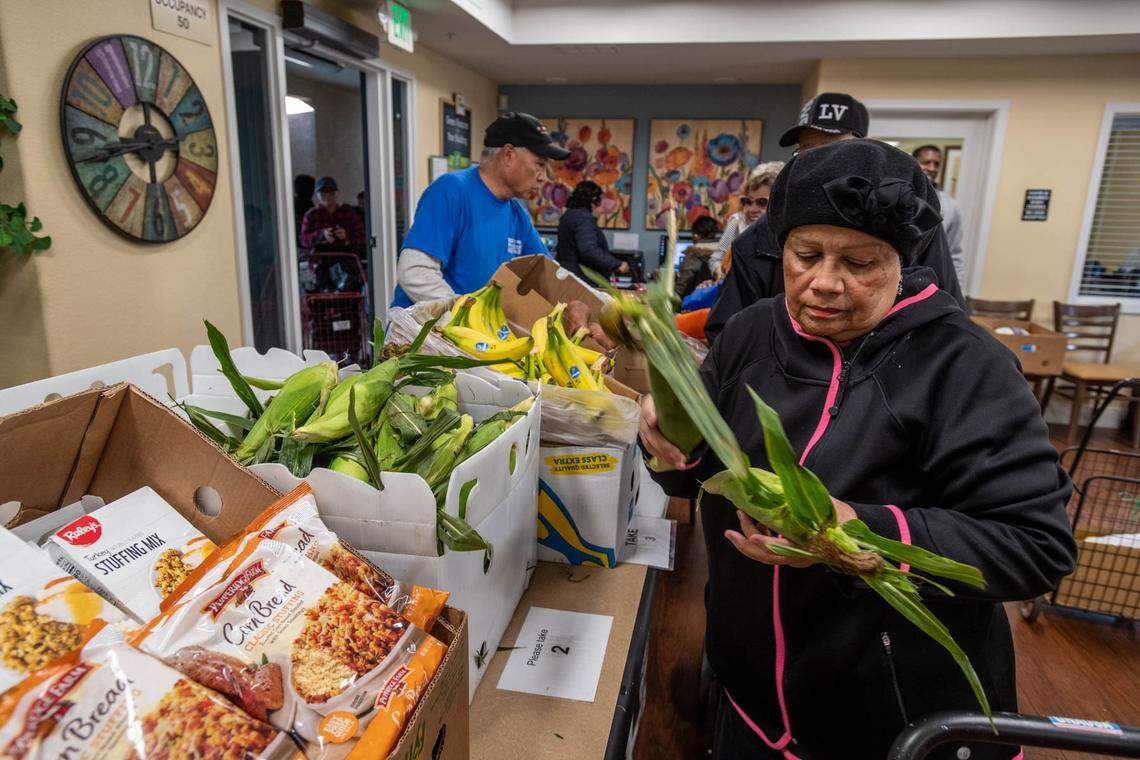 Arbor Creek Family Apartments resident Miriam Cruz gathers groceries donated by the Elk Grove Food Bank Services in November. The organization asks Book of Dreams readers for donations to resume mobile cooking classes for seniors.