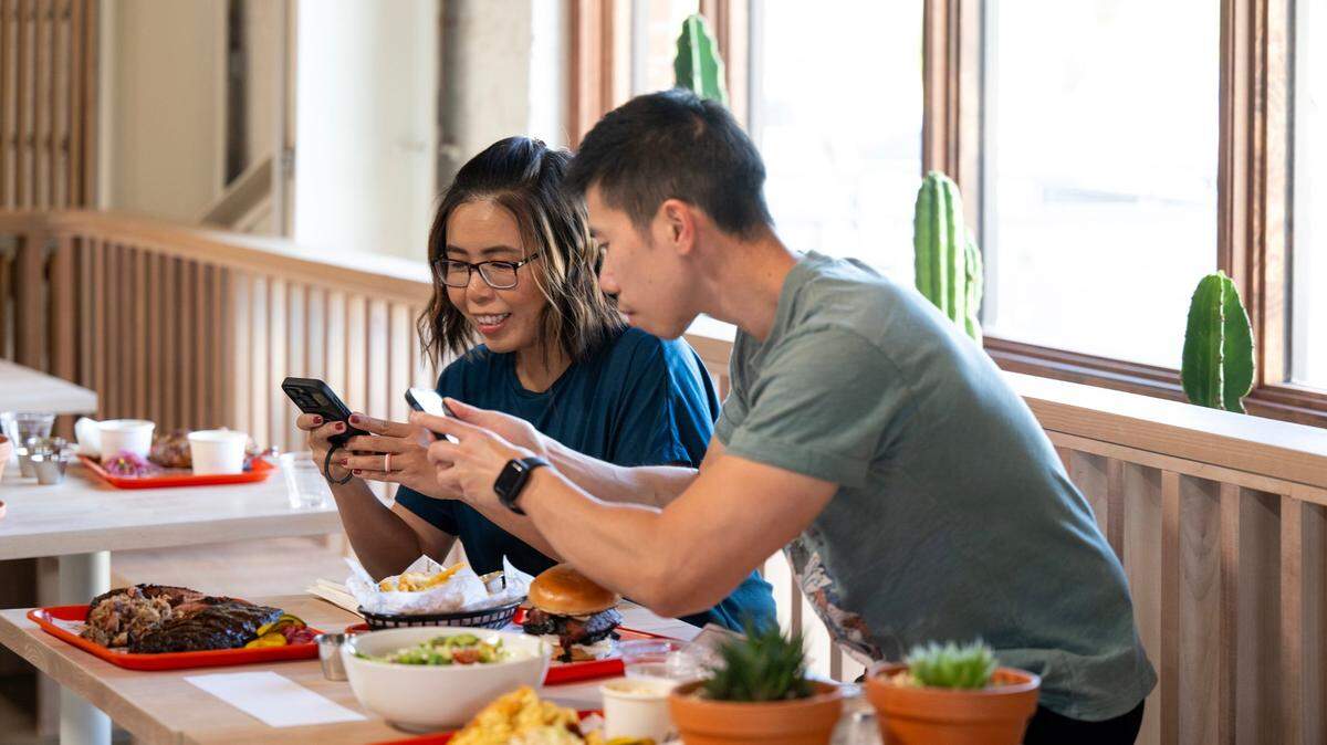 Wendy Lam and her brother David Lam photograph food they ordered at Slow & Low Smokehouse during the restaurant’s soft opening on Wednesday, May 29, 2024, in Elk Grove.