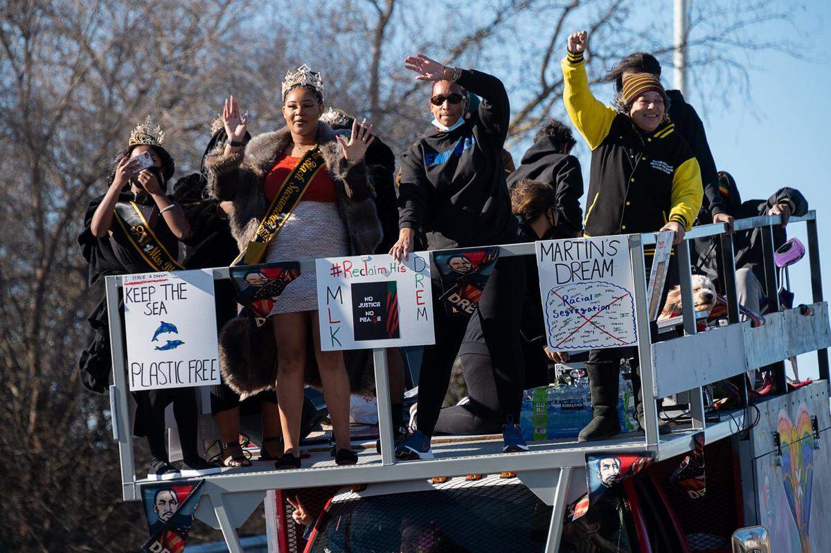 A truck carries a platform filled with people celebrating Martin Luther King Jr. Day as part of a #ReclaimMLK Day car caravan on Monday, Jan. 18, 2021 in Sacramento. Wearing crowns are Miss Black Teen Sacramento 2020 Bethany Onic, left, and Miss Black Sacramento 2020.