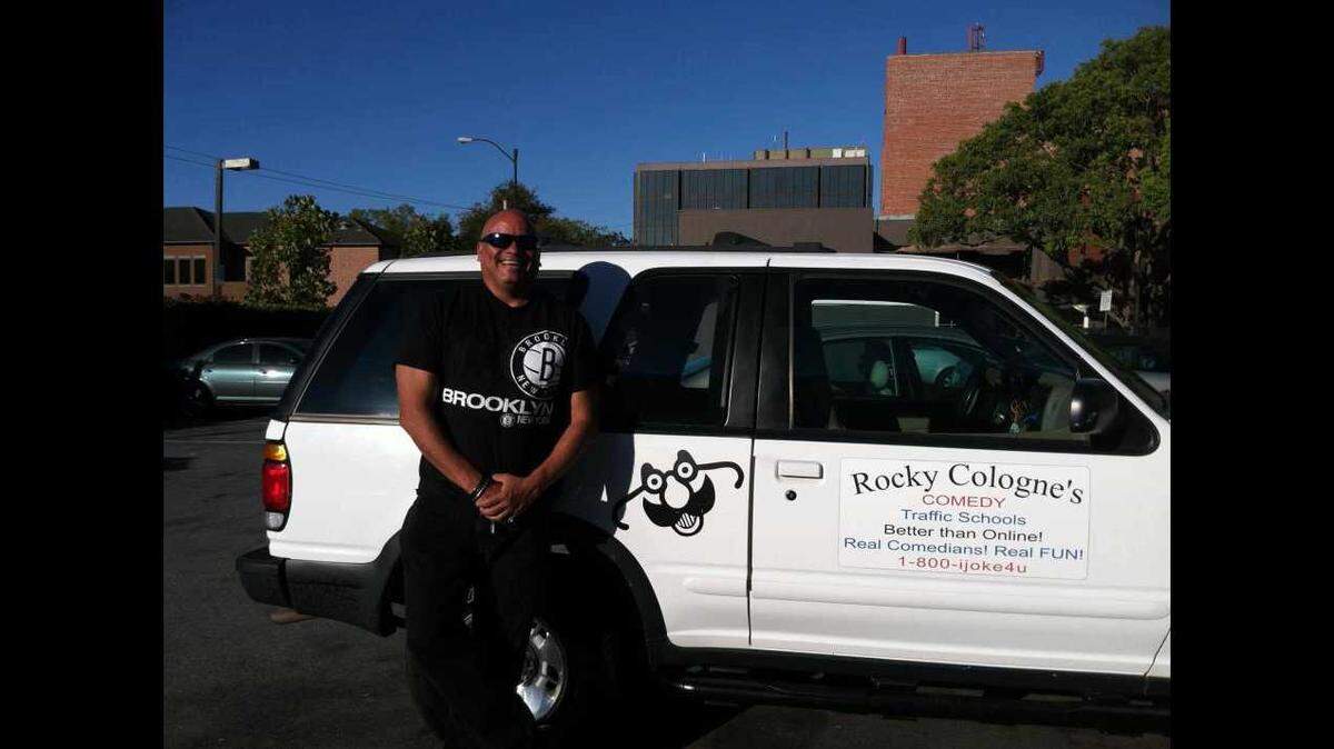Rocky Cologne stands in front of his Comedy Traffic School vehicle.