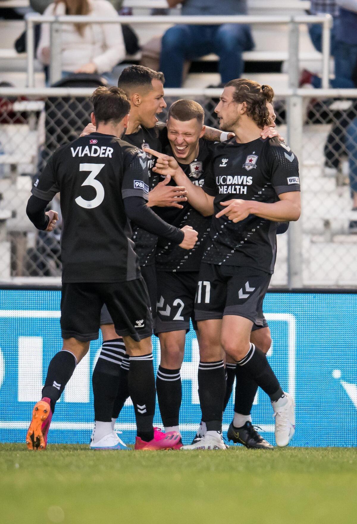 Sacramento Republic FC forward Russell Cicerone (11), right, and midfielder Luis Felipe (96) surround laughing defender Jack Gurr (2) after his goal during the first half against Louisville City FC at the USL soccer game Saturday, April 1, 2023, at Heart Health Park. Sac Republic shut out Louisville 5-0.