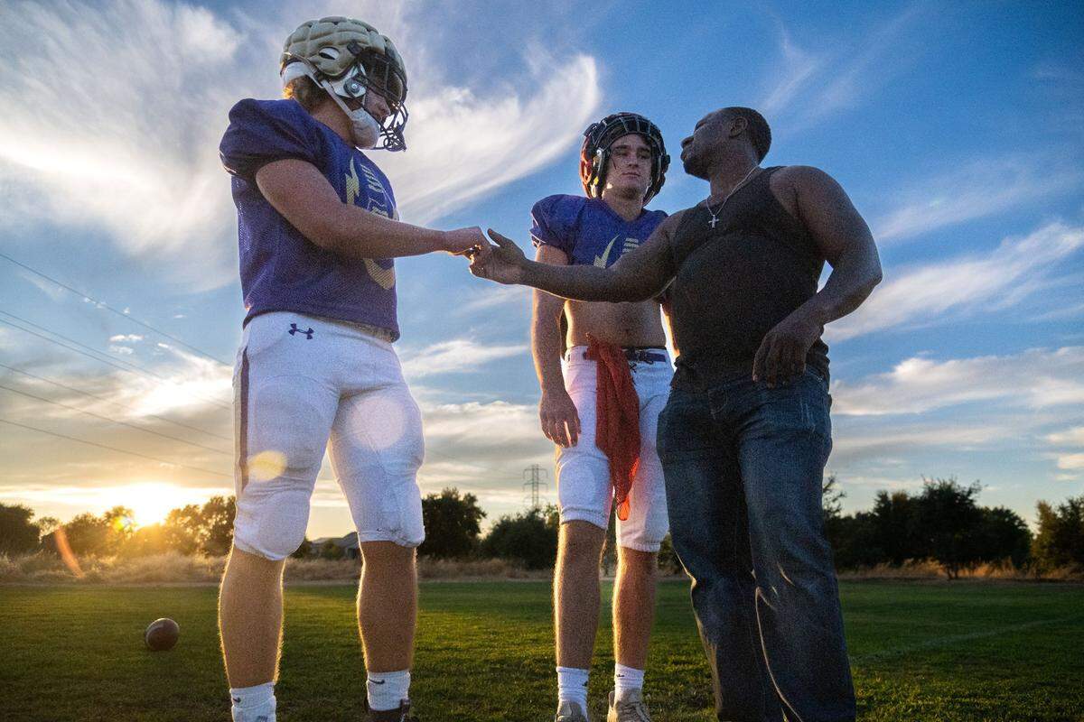 Running back Nathan Zeppieri, left, and quarterback Ethan Rickert talk with assistant coach Deometrius Robinson at Bradshaw Christian High School earlier this month.