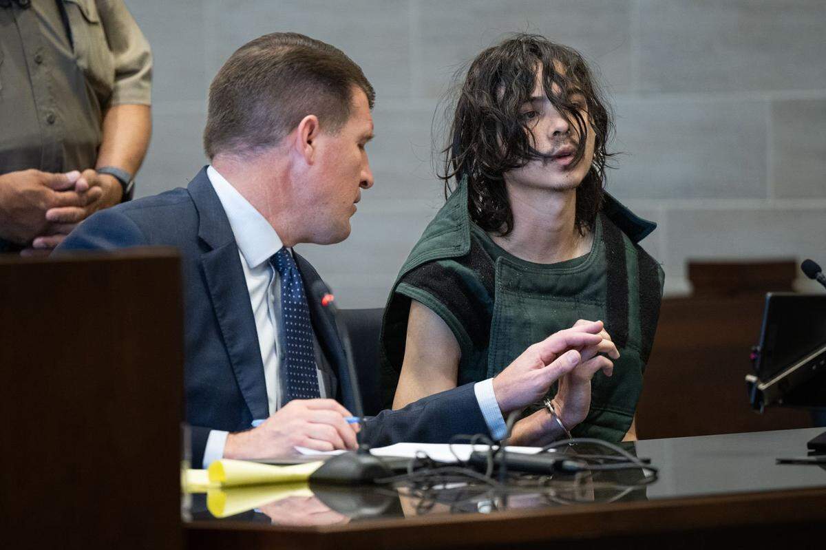 Dan Hutchinson, the court-appointed public defender for Carlos Reales Dominguez, holds the hand of the Davis stabbing suspect as he appears before Yolo Superior Court Judge Samuel McAdam on Tuesday, June 6, 2023.