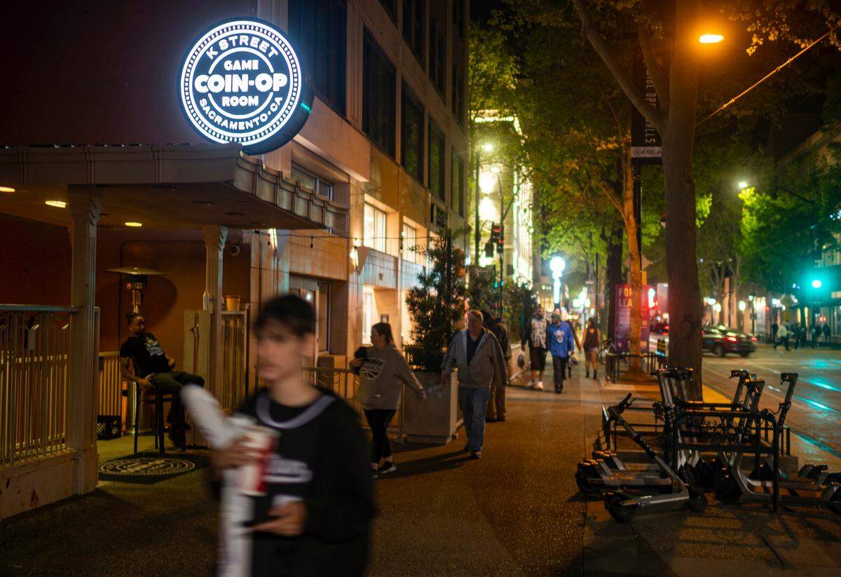 Fans leaving the final Sacramento Kings home game of the season walk past the Coin-Op Game Room on K Street in downtown Sacramento on Tuesday night, April 5, 2022.