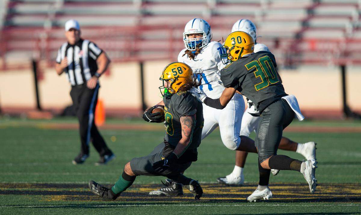 Vanden linebacker Devin Martin (58) drops to a knee after making a fourth-quarter interception to seal a victory for his team in the CIF Sac-Joaquin Section Division IV championship football game at Hughes Stadium in Sacramento on Saturday.