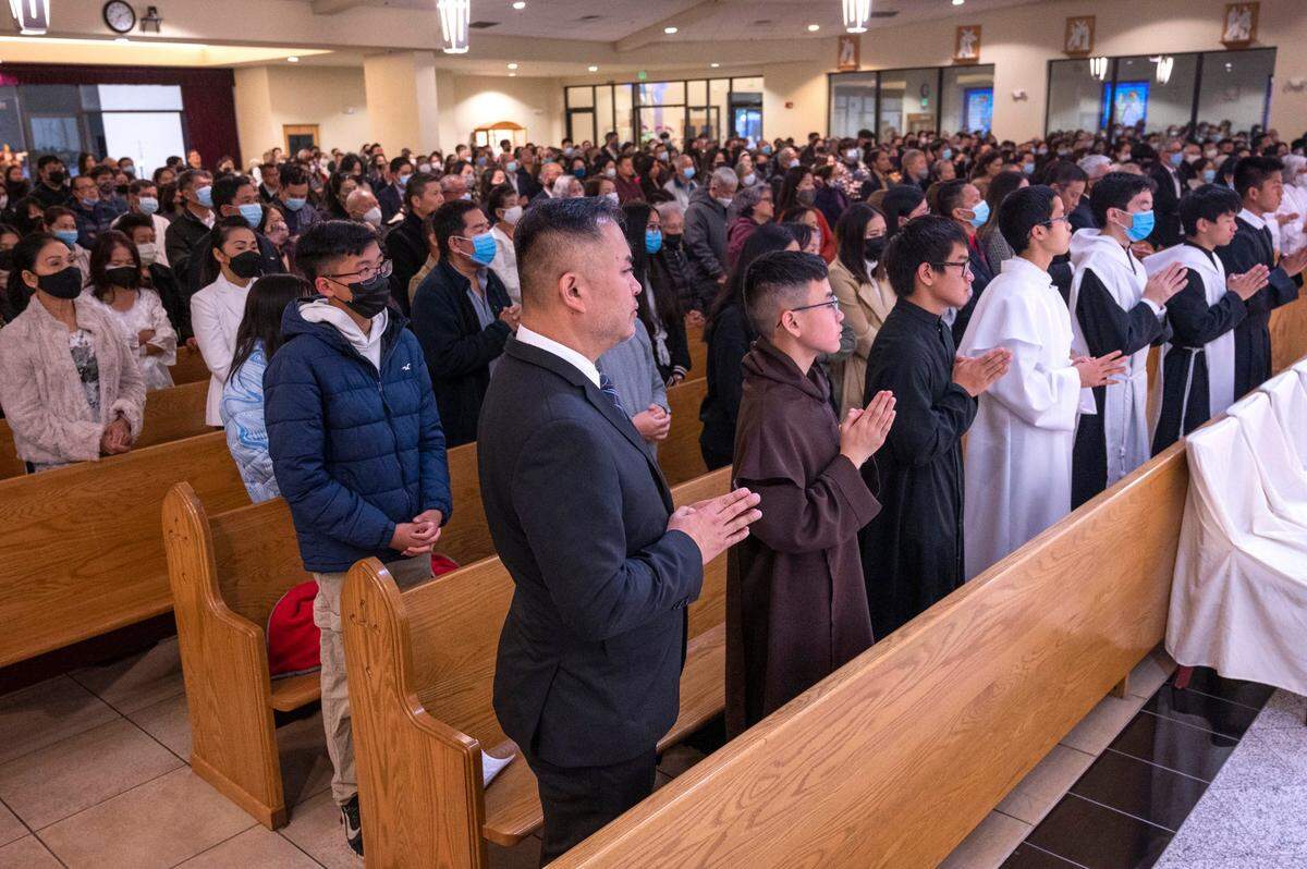 Zachariah Bui of Folsom, front row left, and his son Christian, 13, pray with members of the Vietnamese Martyrs Parish in south Sacramento as they celebrate Holy Thursday with a mass and eucharistic adoration on Thursday. They are expecting to be at full capacity for Easter services.