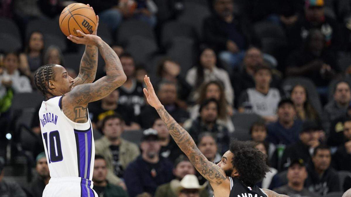 Dec 6, 2024; San Antonio, Texas, USA; Sacramento Kings forward DeMar DeRozan (10) shoots over San Antonio Spurs forward Julian Champagnie (30) during the first half at Frost Bank Center. Mandatory Credit: Scott Wachter-Imagn Images