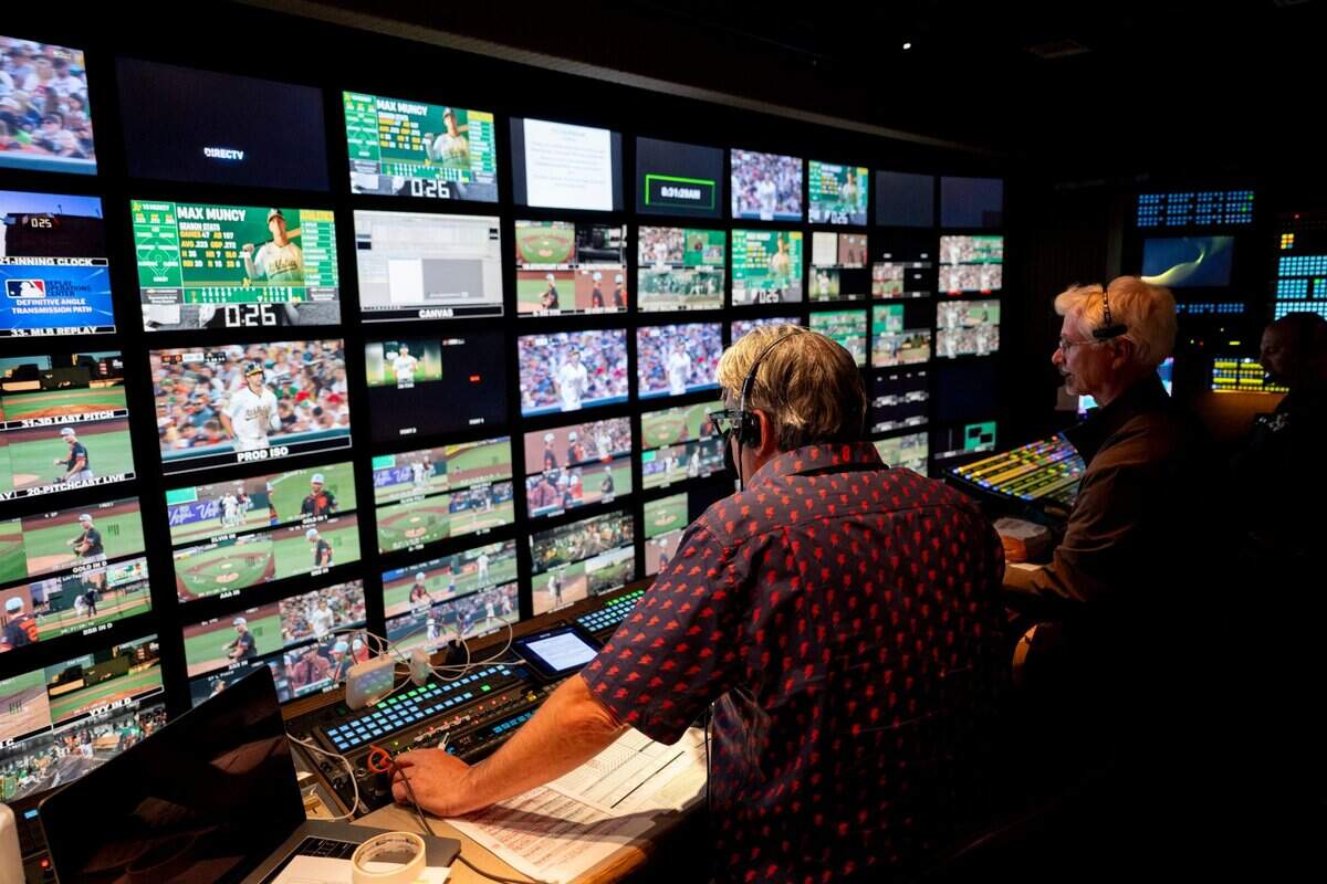 Athletics television producer D’Aulaire Louwerse, left, and Director Tommy Adza, right, sit in the control truck outside Sutter Health Park during a game on July 4. The Sacramento region’s TV market ranks 20th in the nation, ahead of some cities that have MLB teams.