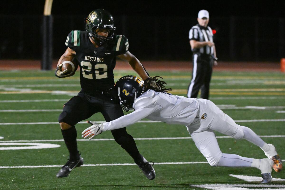 Monterey Trail Mustangs running back D’Adrien Sanders (22) is tackled by Inderkum Tigers linebacker Danny Kirkpatrick (2) in the first half of a 2023 CIF Sac-Joaquin Division I section football quarterfinal.