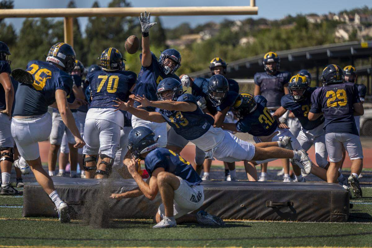 Two defensive players attempt to block an extra point kick during a football practice at Oak Ridge High School in El Dorado Hills on Tuesday, Aug. 5, 2025.