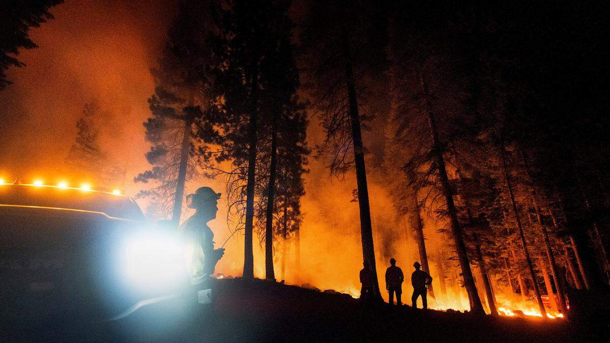 Firefighter Chris Gerking, a Kings County battalion chief, monitors a firing operation, where crews set ground fire to stop a wildfire from spreading, while battling the Dixie Fire in Lassen National Forest, Calif., on Monday, July 26, 2021.