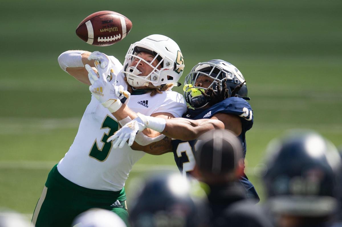 UC Davis’ Devon King, right, breaks up a pass intended for Cal Poly’s Xavier Moore, bringing up a fourth down during the first quarter of the Aggies’ first home football game of the spring season Saturday, March 20, 2021, in Davis. Saturday marked the 1,000th football game in the storied history of the UC Davis Aggies.