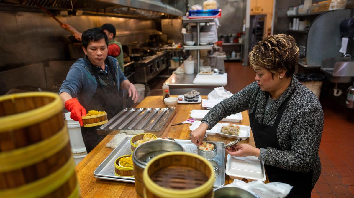 Manager Paula Yang works with her staff in the kitchen to cook dishes for take out orders at King Palace on Stockton Boulevard on Monday, April 6, 2020. King Palace had to temporarily cut its staff from around 30 to just four.