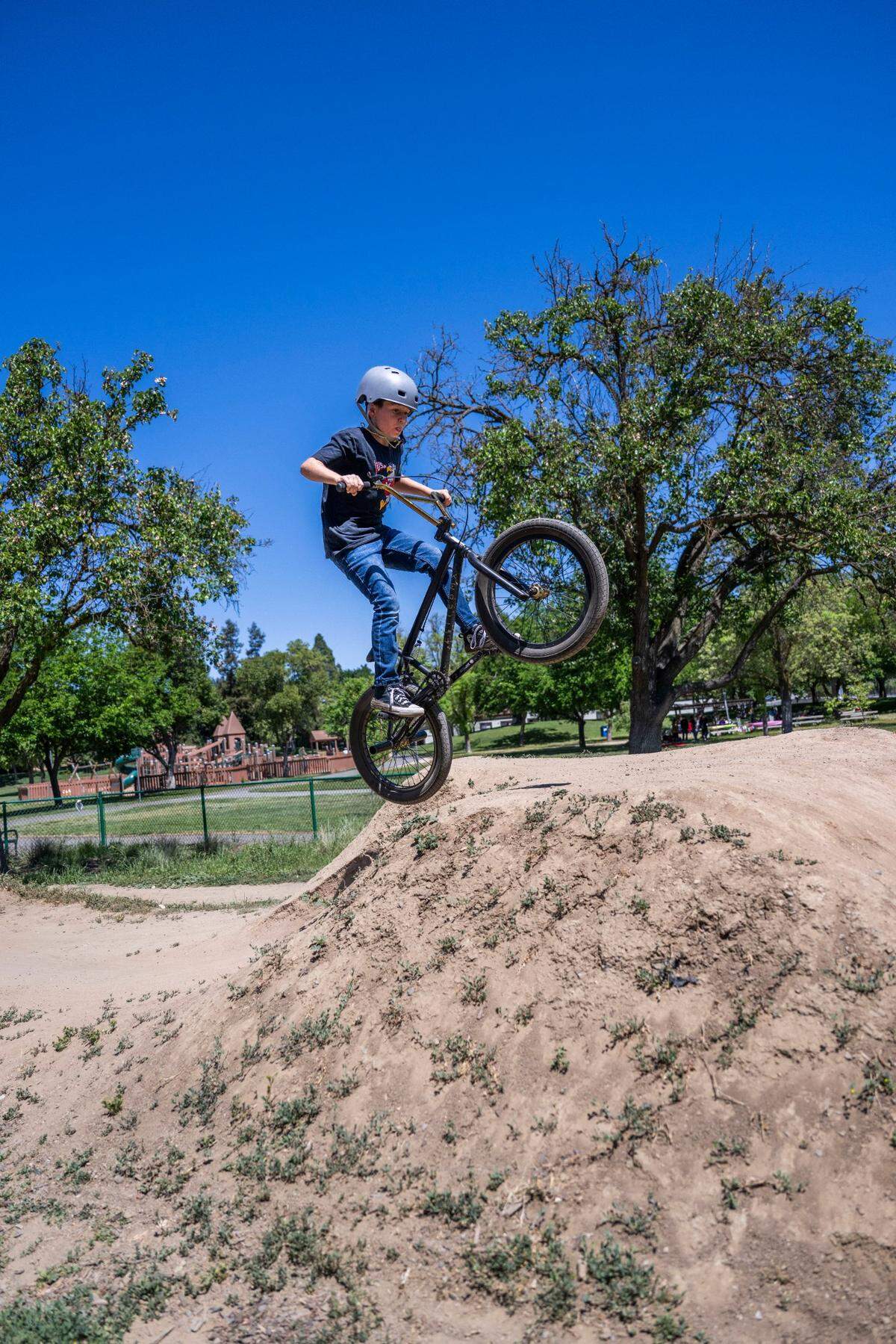 A young dirt bike enthusiast rides his bike on the Community Park bike pump track in Davis the weekend after a shooting at the park on Picnic Day.