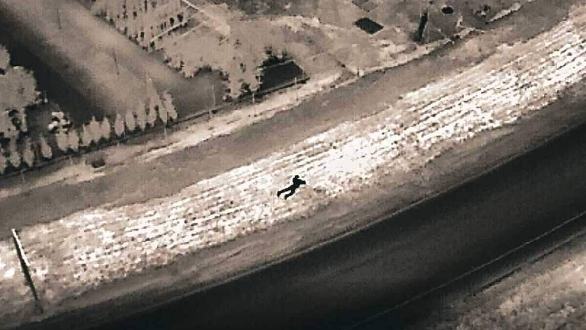 A suspect wanted in connection with a vehicle burglary is seen lying in the grass near a freeway offramp from a police drone. Elk Grove police arrested the man, identified as a 31-year-old man.