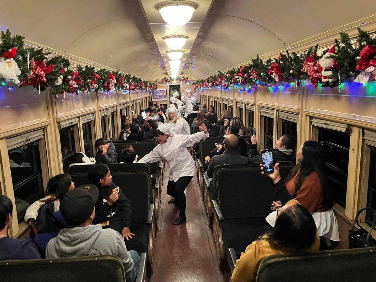 Passengers ride in the coach cabin during The Polar Express train experience in Sacramento in November 2023.
