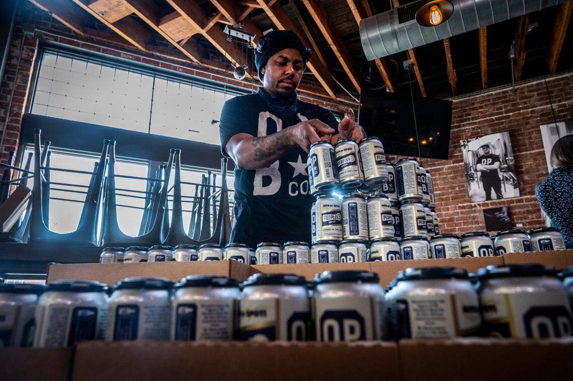 Rodg Little, brewer at Oak Park Brewing, stacks cans of beer after they were canned and labeled in 2020.