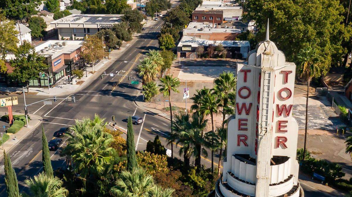 The landmark Tower Theatre sign at Broadway and Land Park Drive is seen in a drone photo looking east over a relatively quiet Broadway on Saturday afternoon, Oct. 6, 2022, in Sacramento.
