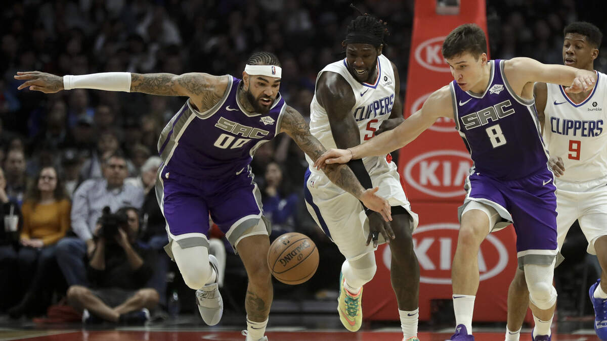 Sacramento Kings center Willie Cauley-Stein, left, and guard Bogdan Bogdanovic, right, take the ball away from Los Angeles Clippers forward Montrezl Harrell, center, during a game Dec. 26 in Los Angeles.