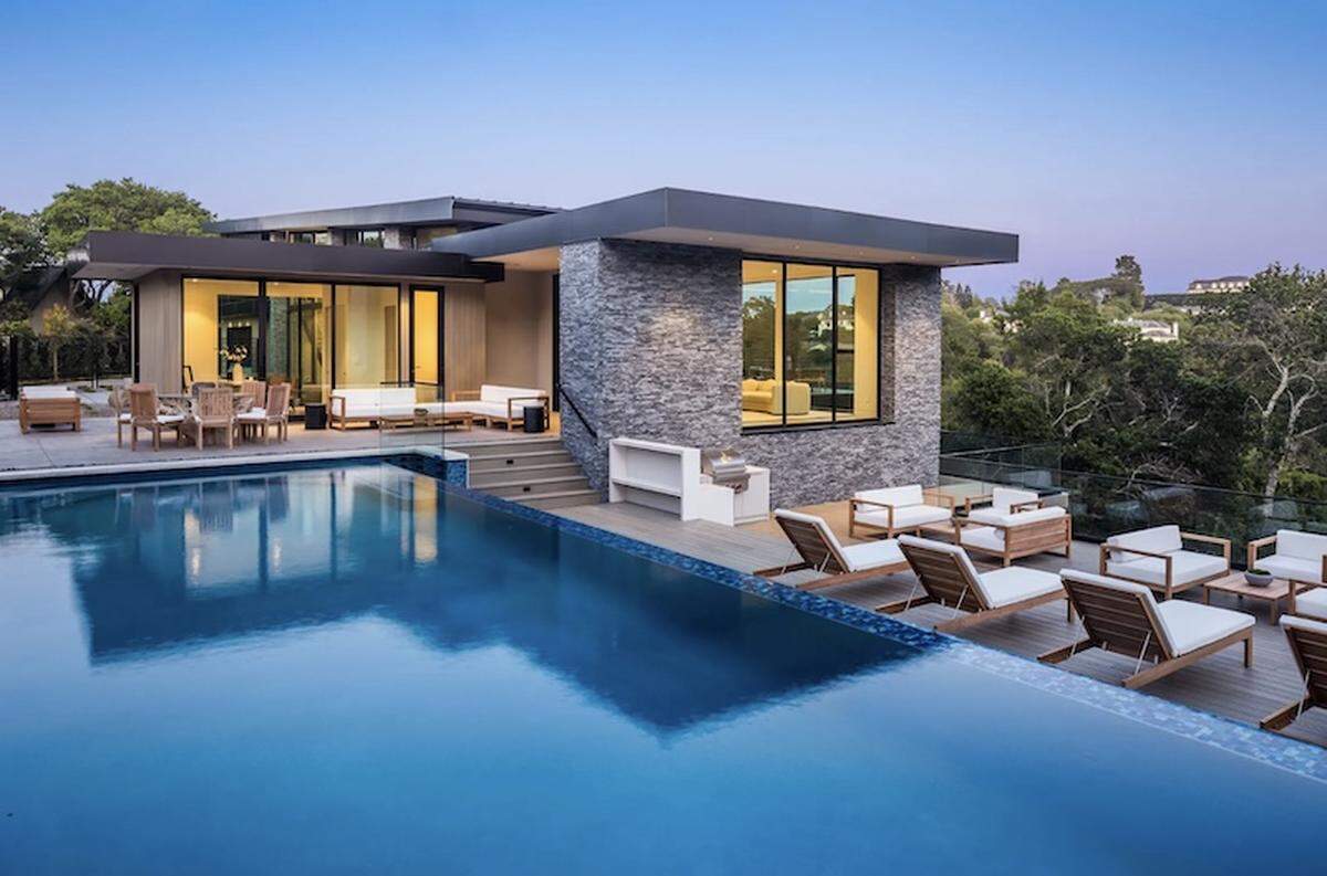 The infinity-edge pool appears to hover above the hillside, offering panoramic vistas and effortless indoor-outdoor living.