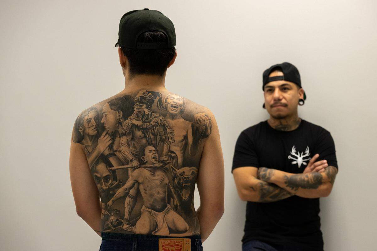 Tattoo artist Cristiano Ochoa, left, displays a creation by tattoo artist Edgar Avila at Elk Grove Tattoo earlier this month.