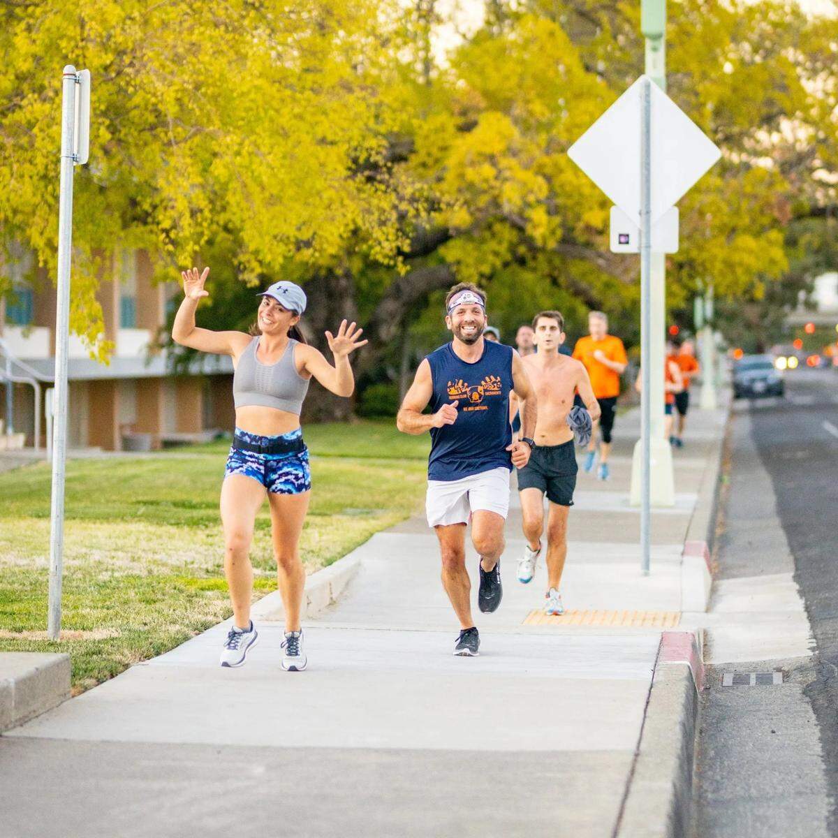 Sara Wolf, left, and Greg Shirey, right, members of Sloppy Moose Running Club, jog down a tree-lined street on Sept. 30, 2021, in the Sacramento region before their first official date night.