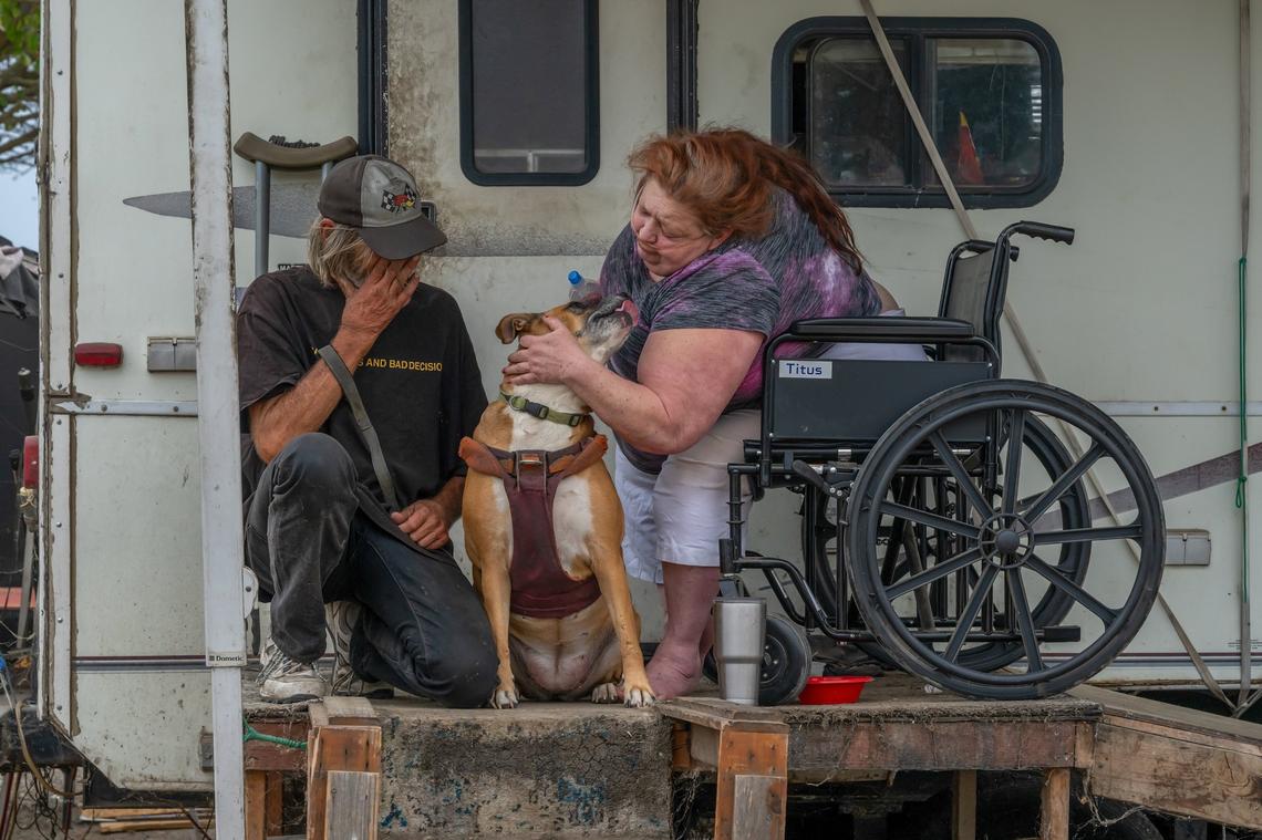 Shonn Adams, 55, who wears an oxygen tube connected from a generator inside her trailer, hugs her dog alongside her friend Steven Goble, at Camp Resolution on Friday. Sacramento put up notices they will sweep the encampment on Monday. Adams suffers from chronic obstructive pulmonary disease said they still haven’t found her a place to live.