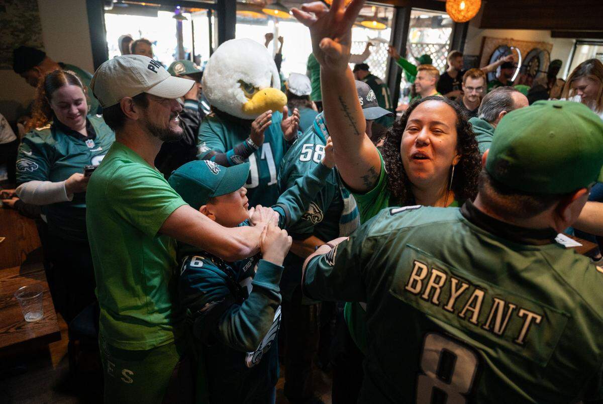 Philadelphia Eagles fans, including Emily McHugh, right, celebrate their team’s win over the Washington Commanders at Limelight sports bar in Sacramento on Sunday, Jan. 26, 2025, during the National Football Conference. The Eagles will head to the Super Bowl.