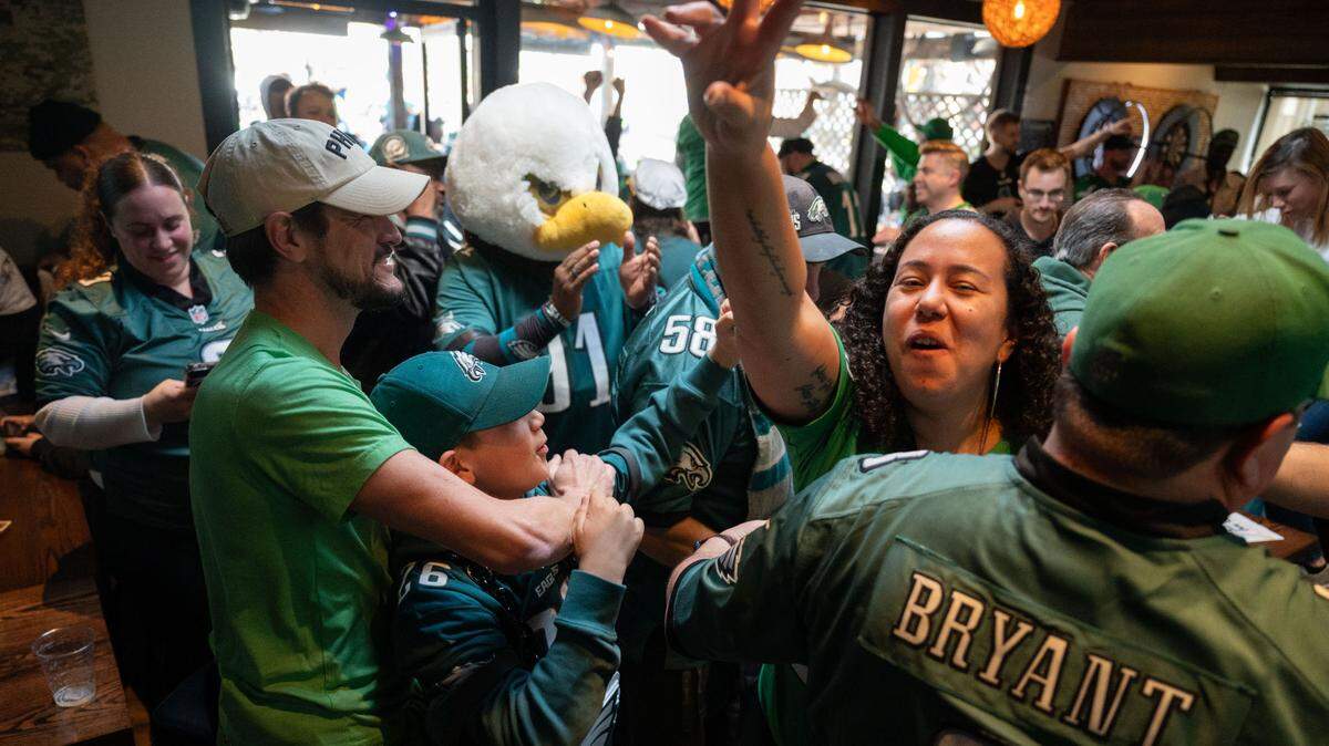 Philadelphia Eagles fans, including Emily McHugh, right, celebrate their team’s win over the Washington Commanders at Limelight sports bar in Sacramento on Sunday during the National Football Conference. The Eagles will head to the Super Bowl.
