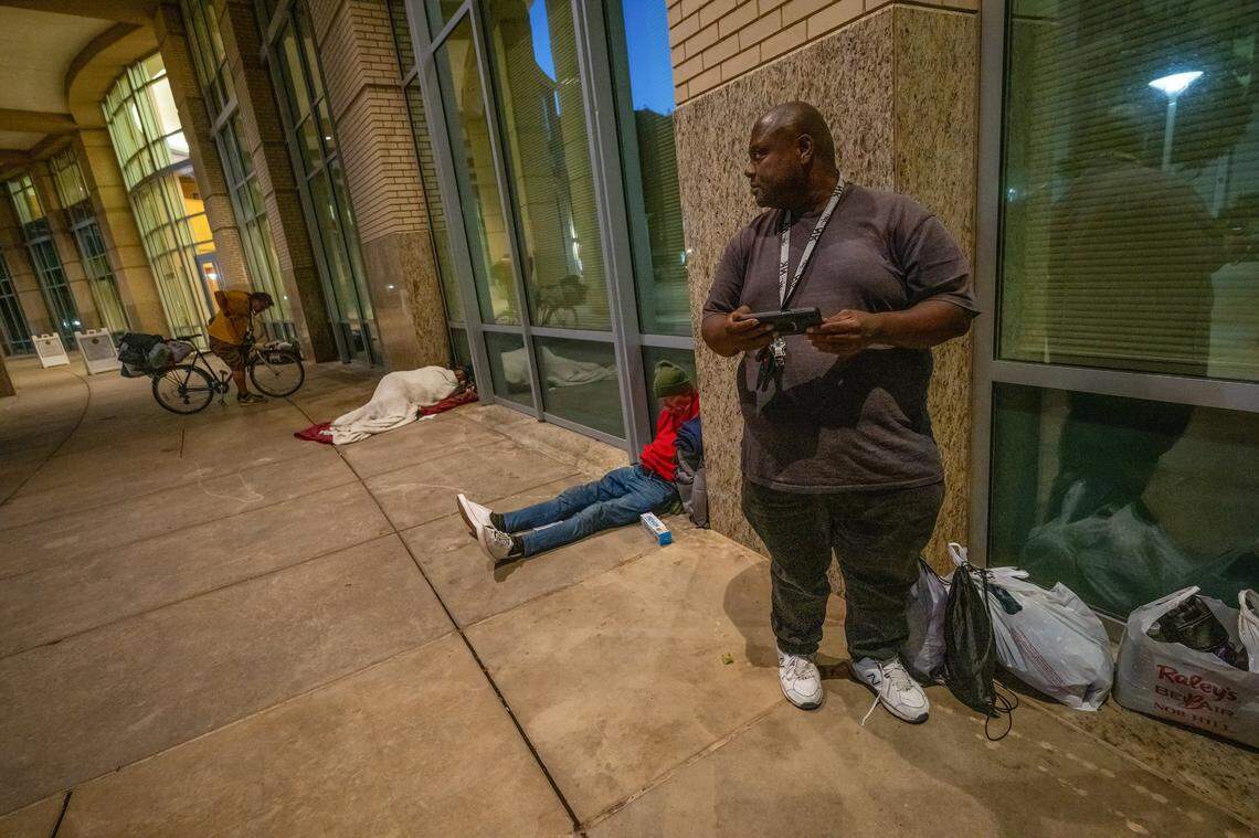 Clint Washington, 52, who has been homeless in for the past four years, gets ready to watch the new Magnum P.I. series on his mobile phone near where he will bed down for the night outside Sacramento City Hall earlier this month.