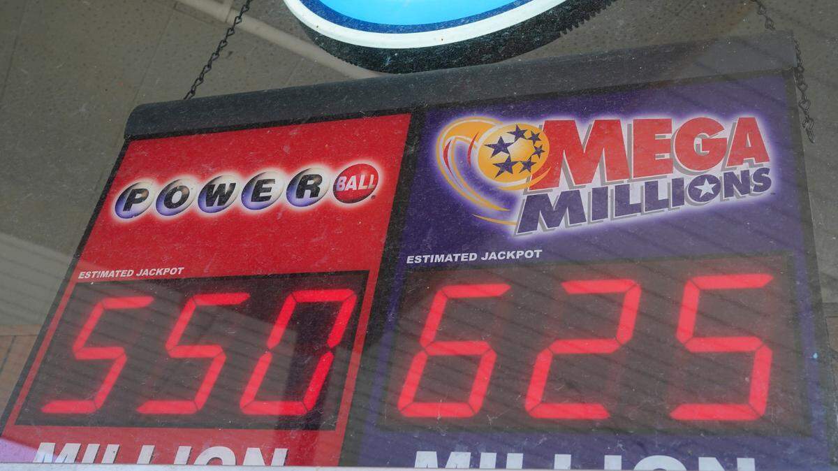 A lottery sign displaying jackpot amounts hangs in the window of a grocery store, Tuesday, Jan. 12, 2021, in Des Moines, Iowa. (AP Photo/Charlie Neibergall)