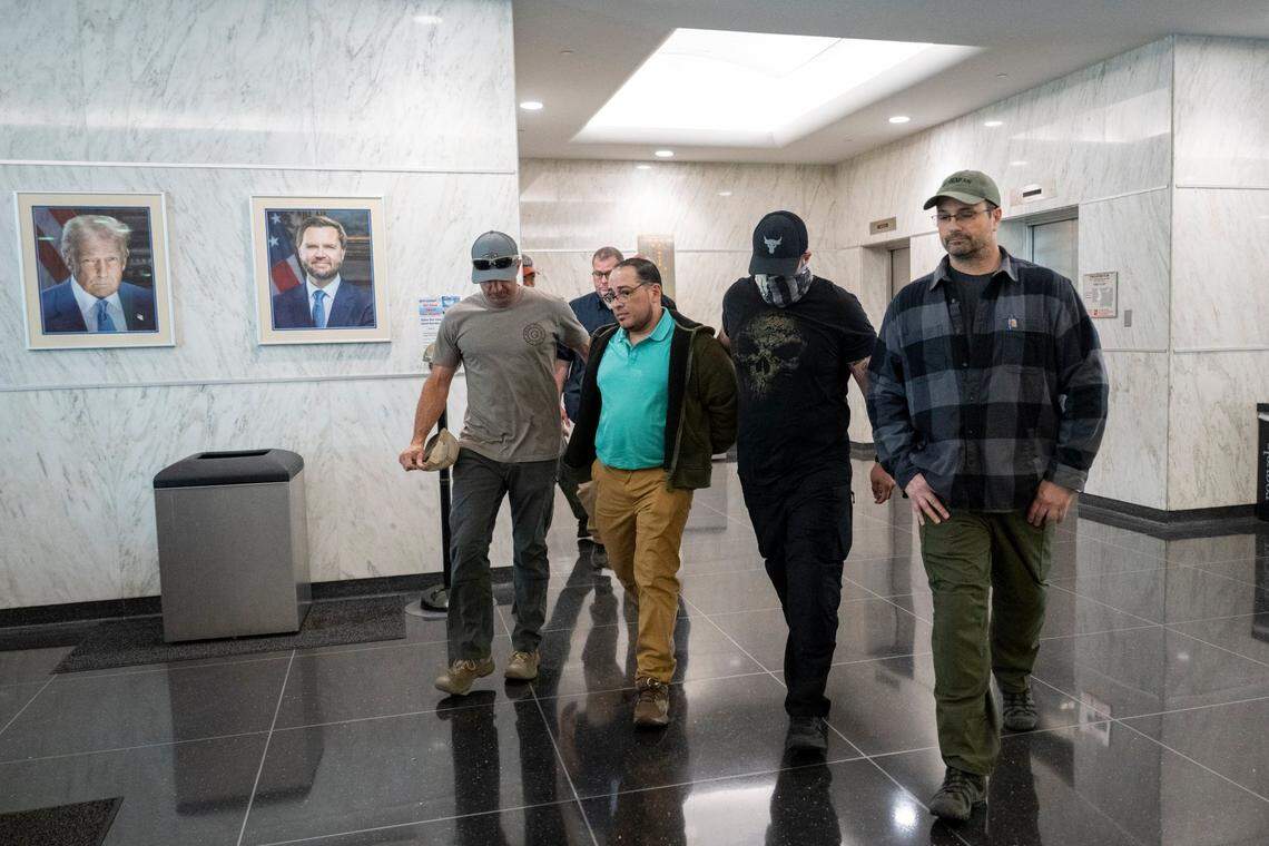 An individual is walked in handcuffs by federal authorities into a U.S. Immigrations and Customs Enforcement office in the John E. Moss federal building in downtown Sacramento on Wednesday, June 11, 2025.