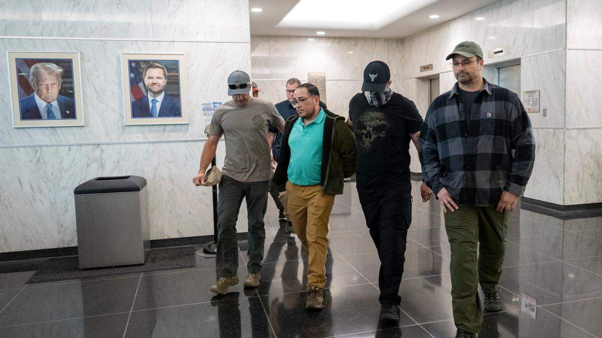 An individual is walked in handcuffs by federal authorities into a U.S. Immigration and Customs Enforcement office in the John E. Moss federal building in downtown Sacramento on Wednesday.
