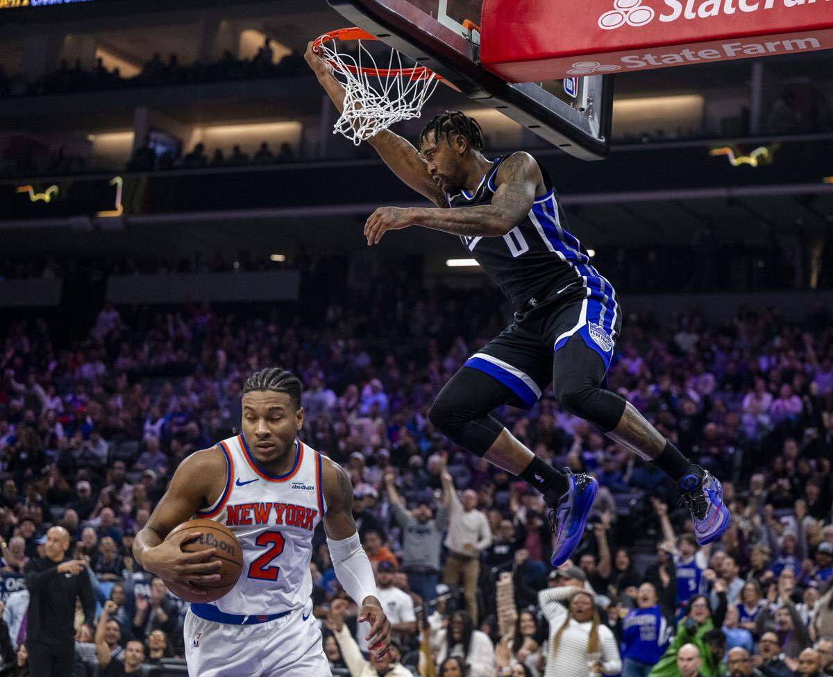 Sacramento Kings guard Malik Monk (0) follows though on a dunk against New York Knicks guard Miles McBride (2) at Golden 1 Center on Wednesday.